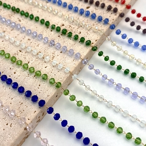Detailed close-up of multi-colored faceted crystal beads on thin chains for necklaces