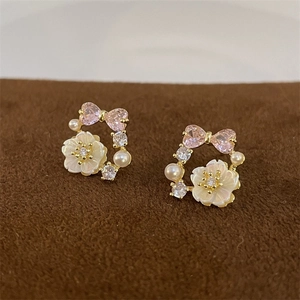 Detail of vintage pink heart crystal bow earrings with white shell flower and pearls