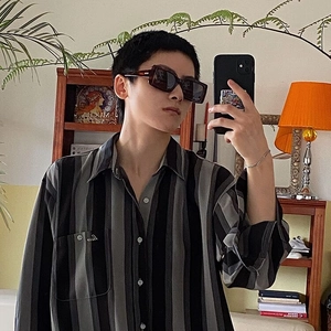 Détail d'une chemise décontractée à manches longues à rayures noires et grises avec poche