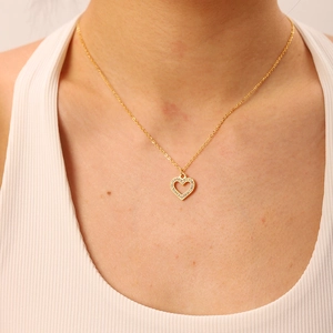 Detailed view of an 18K gold plated heart pendant necklace with zircon on a model