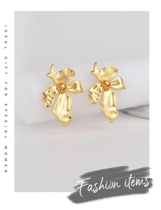 Detailed close-up of gold-plated brass flower earrings with elegant textured petals