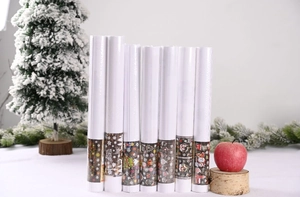 Detail of seven Christmas wrapping paper rolls with festive prints and holiday props