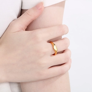 Close-up of a minimalist 18K gold irregular geometric liquid ring worn on a finger