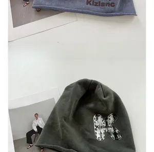 Close-up of knit beanies featuring vintage K-letter patch and Kizlanc embroidery