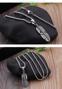 Detailed view of a silver feather pendant with a robust box chain and lobster clasp