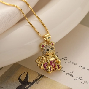 Macro shot of gold-plated bear pendant with pink rhinestones on a delicate box chain