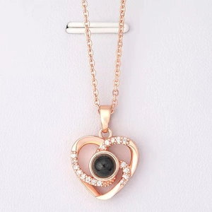 Detail of rose gold double heart pendant featuring a black projection stone and zircon inlay