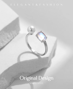 Macro detail of silver open ring with round pearl and iridescent moonstone inlay