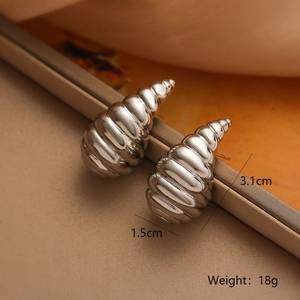 Dettaglio macro di orecchini a conchiglia d'argento con dimensioni di 3,1 cm e 1,5 cm