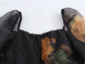 Détail du col carré élégant et des manches bouffantes en organza à fleurs jaunes