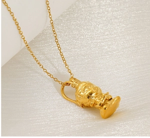 Macro shot of gold-plated necklace featuring a 3D cartoon pendant on pearl surface