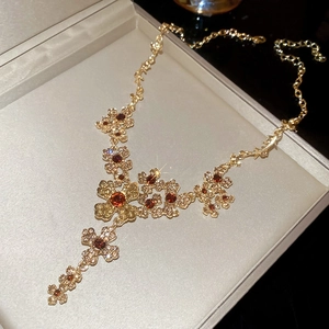 Macro shot of gold floral necklace with amber stones in a velvet jewelry box