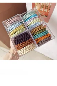 Detail of 4-box set macaron spiral hair ties in assorted earthy tones and square containers