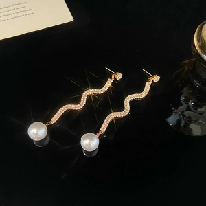 Elegante goldene Wellen-Ohrringe mit Kristallen und großen weißen Perlen