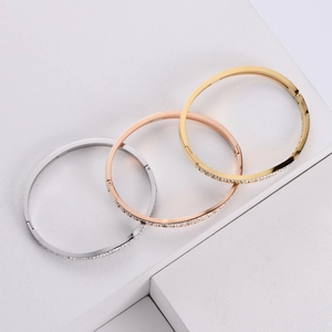 Detailed view of silver, rose gold and gold cubic zirconia bangles on geometric stands