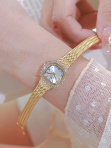 Close-up of a vintage golden square watch for women with rhinestones and mesh strap