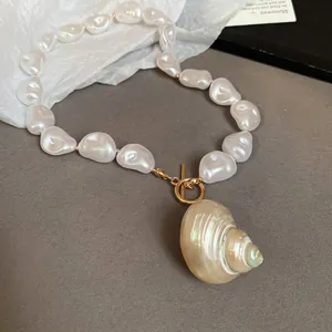 Elegant baroque pearl necklace featuring a natural conch shell pendant and golden OT clasp