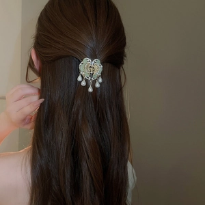 Detail of floral hair stick with white pearls and long tassels on model hair