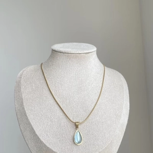 Vintage gold-plated titanium steel necklace featuring a light blue teardrop pendant on mannequin