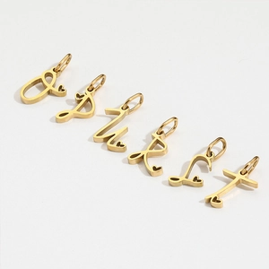 Golden titanium steel letter pendants with heart charms on white background