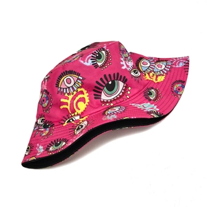 Close-up of pink bucket hat with colorful eye graffiti pattern and street style detail