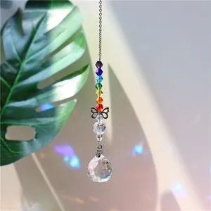 Suncatcher with rainbow crystal beads and metal butterfly reflecting light on wall