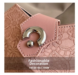 Detail of pink lace handbag featuring a decorative silver metal clasp and floral texture