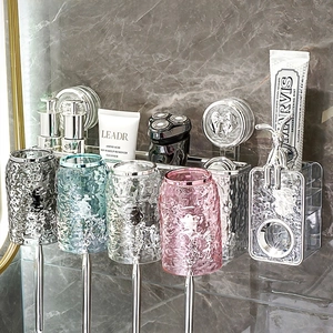 Detail of wall-mounted bathroom organizer with four hammer-patterned colorful cups