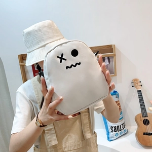 Gros plan d'un mini sac à dos blanc avec visage rigolo tenu par un mannequin