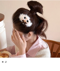 Close-up of white plush Siamese cat hair claw clip on female model's bun hairstyle