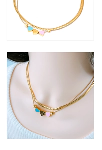 Close-up of double-layer snake chain with pink and blue heart pendants and engraved details