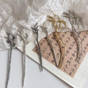 Close-up of metallic tassel hairpins with bamboo and plum blossom textures in three colors
