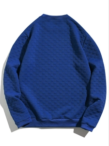 Detailed view of the dark blue quilted checkerboard texture on men's long sleeve sweatshirt