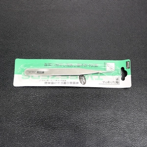 Macro detail of anti-magnetic stainless steel precision tweezers in green blister packaging