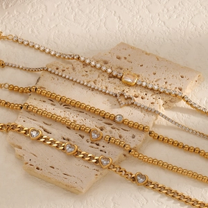 Luxurious 18k gold plated tennis bracelets with heart and zircon stones on stone display