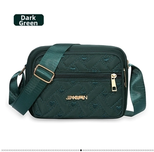Detail of dark green nylon bag featuring heart-shaped quilting and gold metal logo