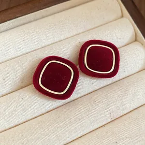 Détails de boucles d'oreilles carrées en velours rouge avec bordure en métal doré