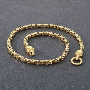Detailed view of golden Byzantine chain necklace featuring skull ends and ring clasp