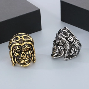 Detailed view of punk skull pilot rings in vintage gold and silver stainless steel finishes