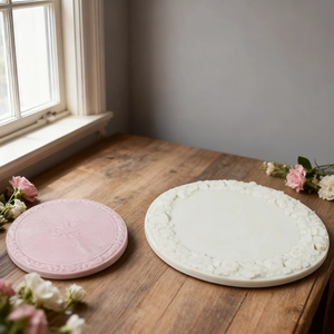 Detail of floral relief round resin molds showing pink and cream plaster flower coasters