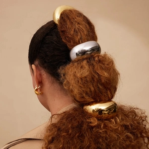 Polished gold and silver stainless steel hair rings on ponytail with sleek metal finish