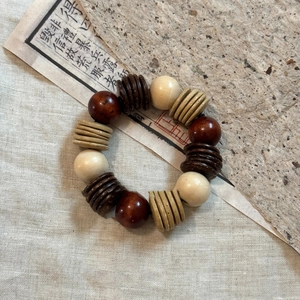 Detailed view of bohemian coconut shell and wooden beads on vintage handmade paper