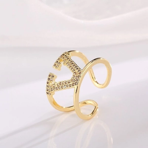 Macro detail of gold-plated V-shaped ring featuring sparkling white zircon inlay