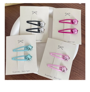 Close-up of colorful star BB hair clips in pink, blue, purple, and black on display cards