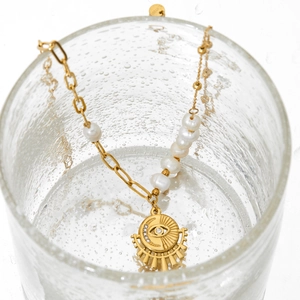 Golden stainless steel necklace with pearls and evil eye sun pendant in water glass