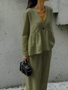 Close-up of green cotton linen fabric texture on casual V-neck top and pants set