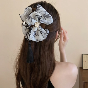 Elegant ink-wash bow hair claw with camellia center and long black tassel detail