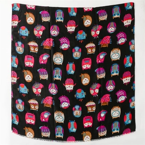 Detail shot of colorful cartoon owl patterns and tassel fringe on black cotton linen scarf