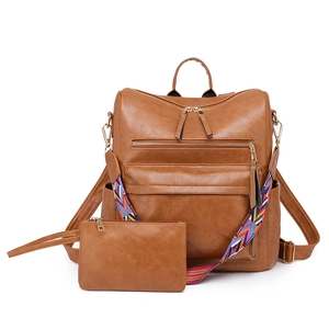 Detail of brown faux leather backpack with woven straps and matching small coin purse