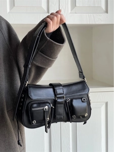 Detailed view of black chic leather underarm bag with zippers and metal grommet accents